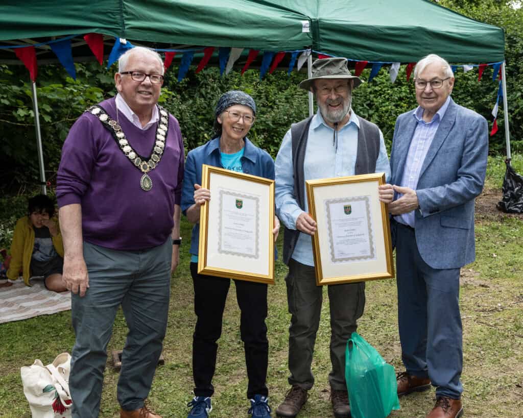 Mayor of Sedgefield Peter Hinde and Chairman of Sedgefield Town Council Mel Carr presenting framed certificates to Sandy & Roger Clubley