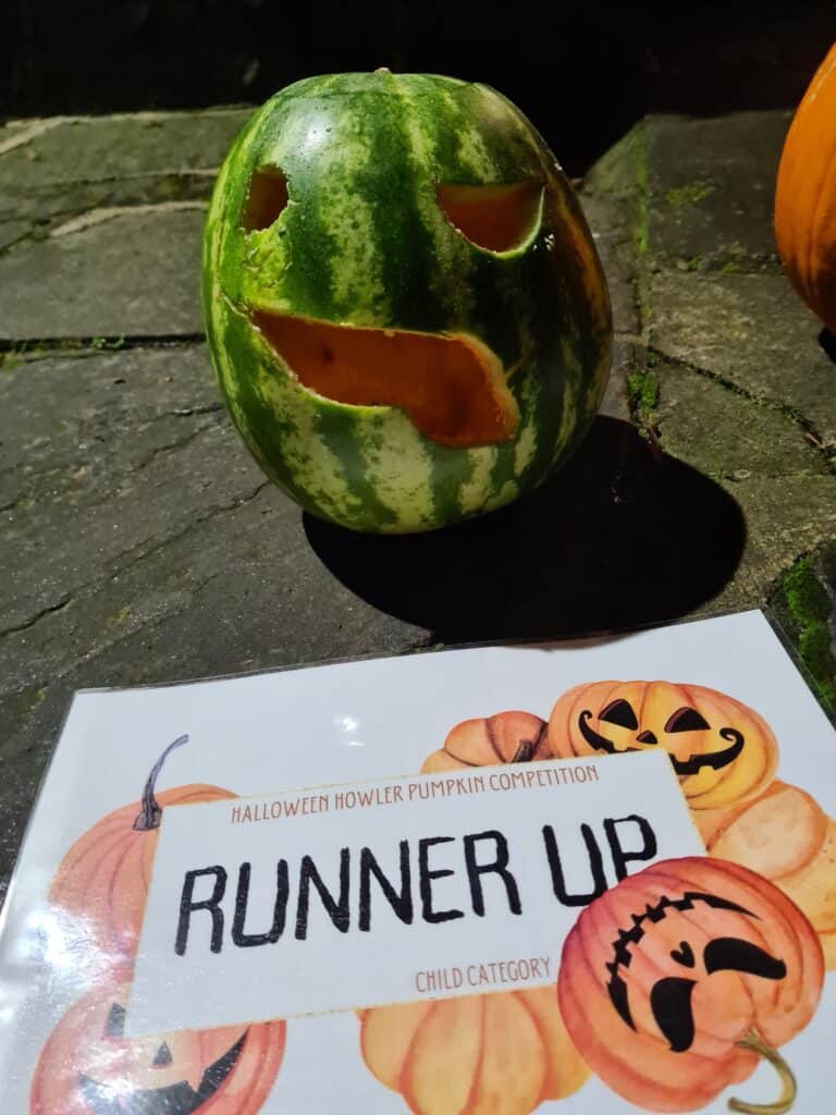 Runner up pumpkin winner with the runner up certificate. A watermelon with a carved face